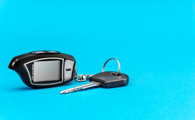 Car remote control with car key on a blue background.