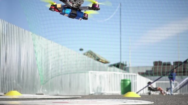 FPV racing drone is taking off the ground in slow motion. Closeup detailed slowmo shot.