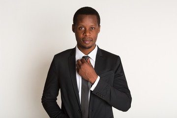 Black man manager straightens tie. Portrait