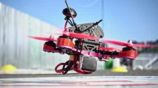 FPV racing drone is taking off the ground in slow motion. Closeup detailed slowmo shot.