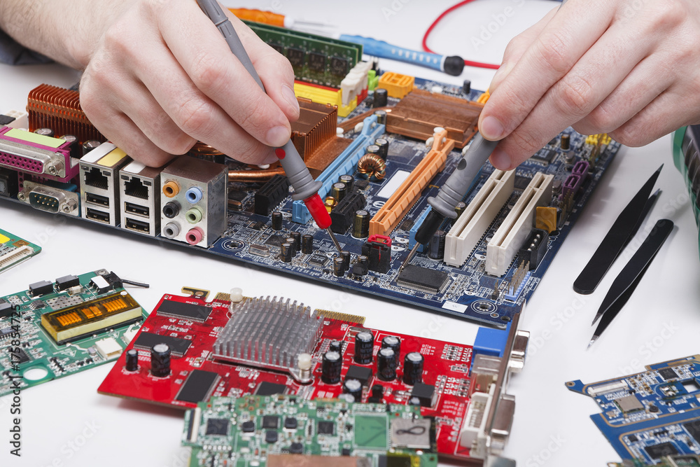 Poster engineer checking motherboard with multimeter