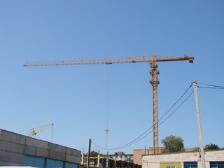 Abstract Industrial background with construction cranes silhouettes over amazing sunset sky