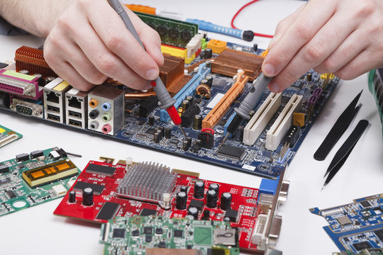 Engineer checking motherboard with multimeter