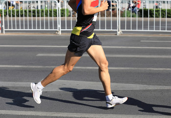 Fototapeta premium Marathon runner running on city road