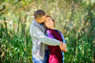 two lovers stroll in the open air, gently hug and look at each other.