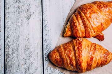 freshly baked croissants on wooden cutting board, top view