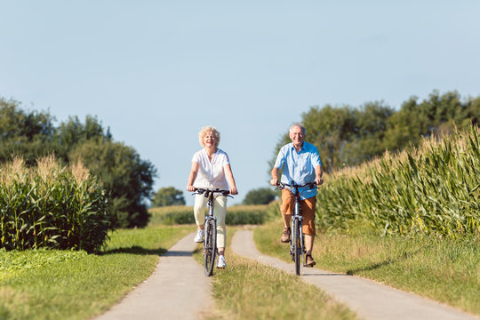 Senioren Frau und Mann bei bester Gesundheit auf dem Fahrrad im Sommer