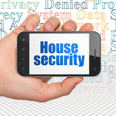 Privacy concept: Hand Holding Smartphone with House Security on display