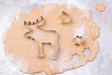 Preparing Christmas gingerbread cookies with cutter, dough and rolling pin.