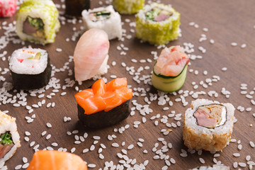 Set of sushi, maki and rolls with sesame on wooden rustic background, closeup