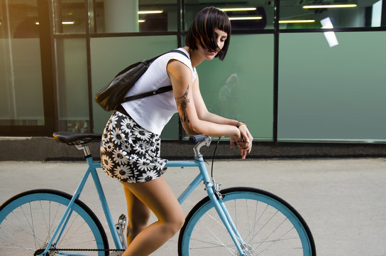 Beautiful modern young adult girl on custom made bicycle posing
