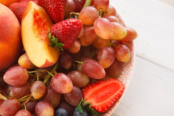 Mixed fruits and berries in glass bowls closeup, top view