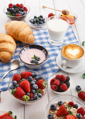 Continental breakfast with croissants and berries on checkered cloth
