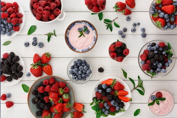 Healthy breakfast with berries and yogurt on white wooden table