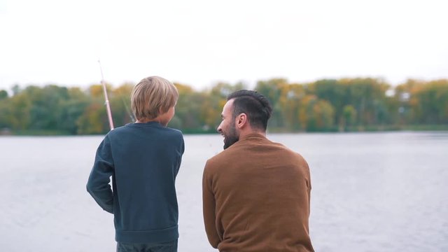 Father shows son how to fish.