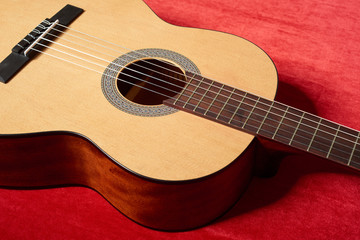acoustic guitar on red velvet fabric, closeup object