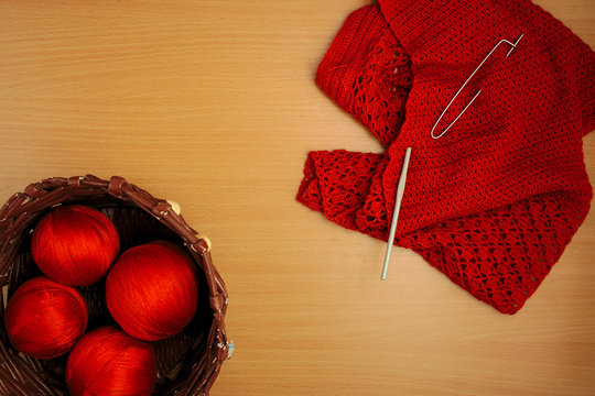 needlework, knitting needles and crochet, jacket and basket of terracotta threads