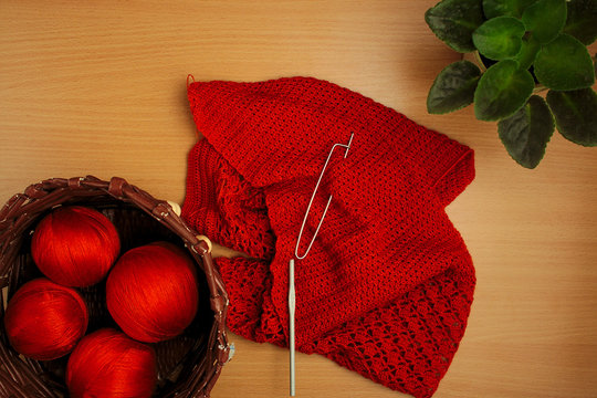 needlework, knitting needles and crochet, jacket and basket of terracotta threads, home flower
