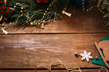 Christmas and New Year holiday background. Close up handmade ornaments and pine on wooden table, festive decoration concept. Free space in the middle