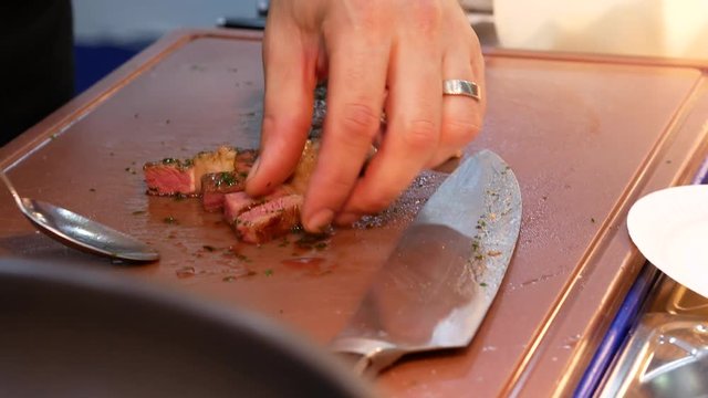 Serving beef steak slices on cutting board.