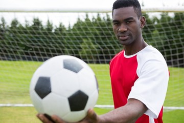 Portrait of male soccer player holding ball