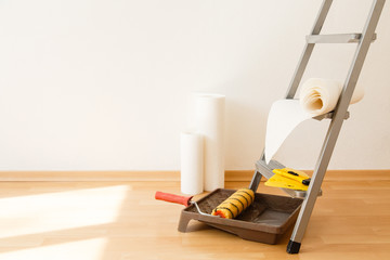 Tools for gluing wallpapers. A room after renovation. Fresh repair in a room. Floor from laminate