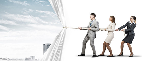 Young businesspeople working in collaboration and pulling white advertisement banner