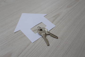 house icon with keys on wooden background