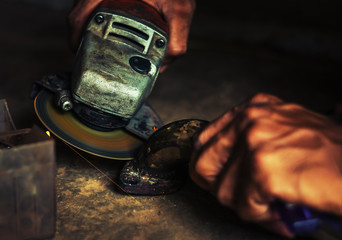 Hand of man with steel cutter tool blurred on black background