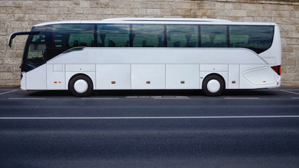 White tourist bus parked on empty road
