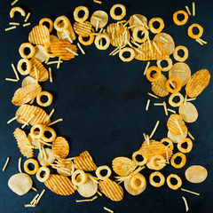 Fast junk food concept onion rings french fries potato chips beer snack unhealthy nutrition. Background with copy space square.