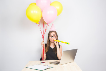 Funny young woman celebrating the success of her business or a birthday in the office holding...