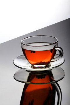 Cup of tea with plate on the reflective surface.Creative reflection.Gradient background.Copy space