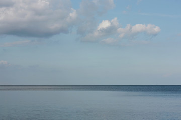 horizon separating  water surface and clouds sky