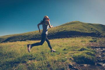 fitness woman trail runner running on grassland trail