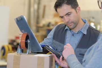 worker with trolley wheel reading the tablet