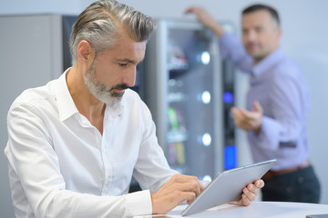 Naklejka na ściany i meble businessman using tablet during break in the office