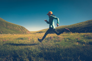 fitness woman trail runner running on grassland trail