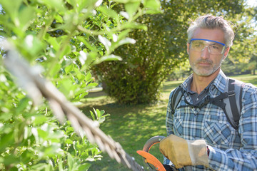Obraz premium Man holding hedge trimmer