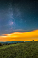 Obraz premium Landscape with the Milky Way as seen from the mountain Katzenbuckel in the Odenwald in Germany.