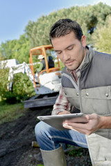 Obraz premium gardener outside with tablet