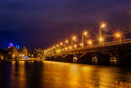 Beautiful illuminated Chernavskiy Bridge through Voronezh river at night