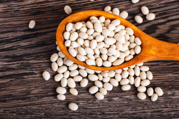 Fototapeta na wymiar Pile of white beans in a wooden spoon.