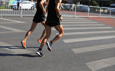 Fototapeta premium Marathon runners running on city road