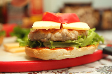 Cooking of burgers with veal, red tomatoes, lettuce, cheese and sauce in the home kitchen