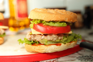 Cooking of burgers with veal, red tomatoes, lettuce, cheese and sauce in the home kitchen