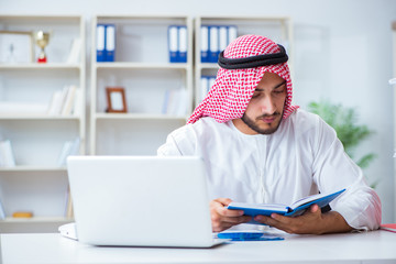Arab businessman working in the office doing paperwork with a pi
