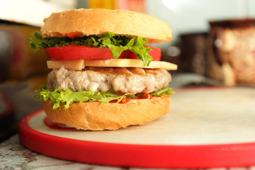 Cooking of burgers with veal, red tomatoes, lettuce, cheese and sauce in the home kitchen