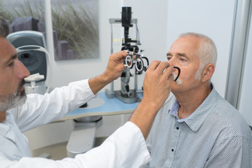 ophthalmologist putting testing glasses on patient