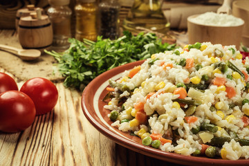Colorful rice and vegetable salad,Bowl of pasta (orzo) or rice with vegetables,selective focus,Appetizing healthy rice with vegetables in plate on a wooden background,Delicious risotto with vegetables